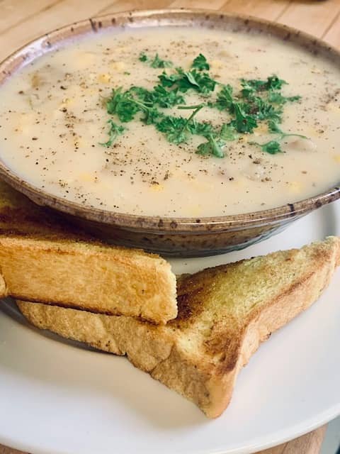 A bowl of soup sitting on top of a white plate