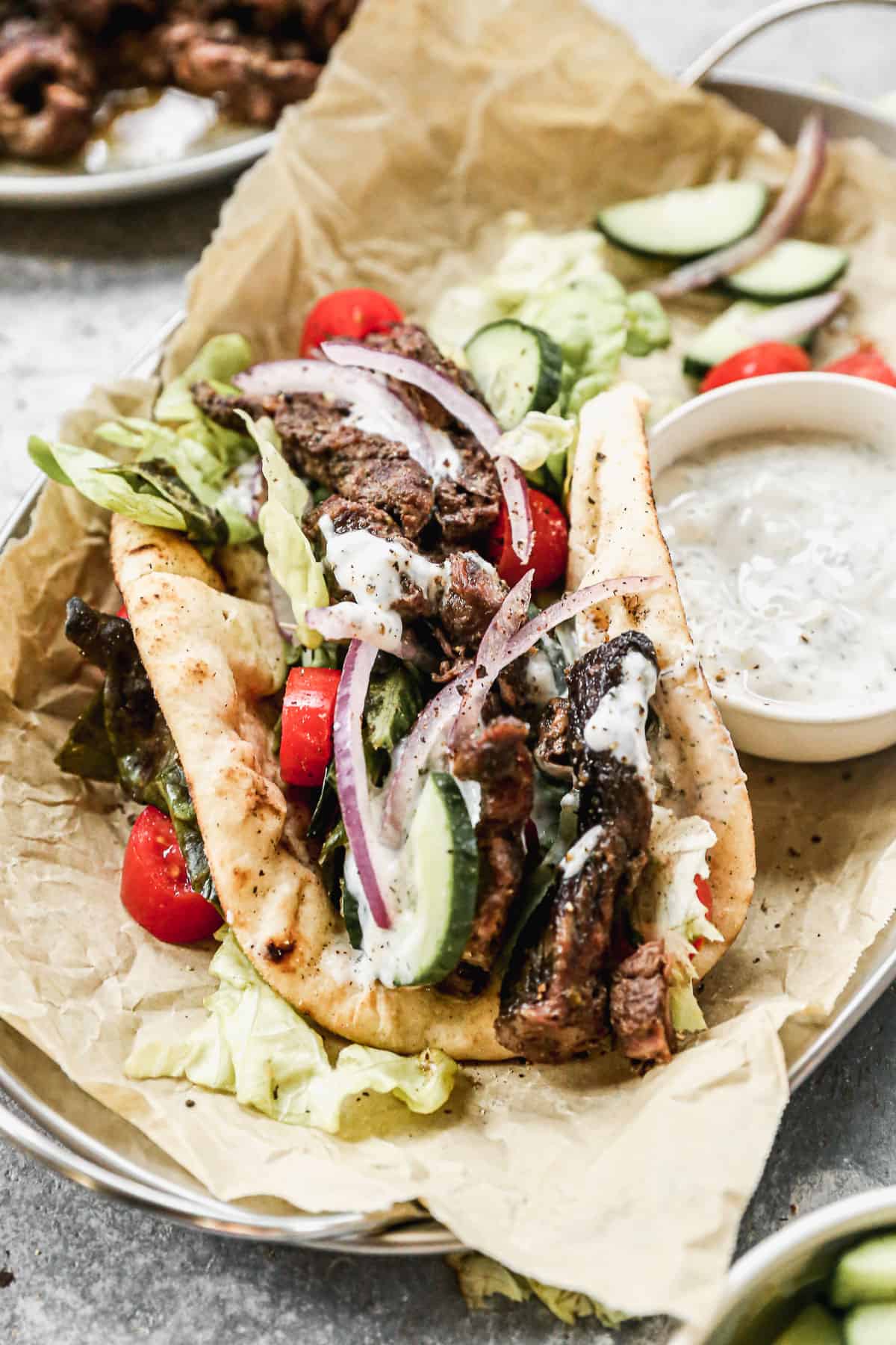 Beef Gyros topped with fresh vegetables, and a homemade tzatziki sauce, served in a paper lined basket