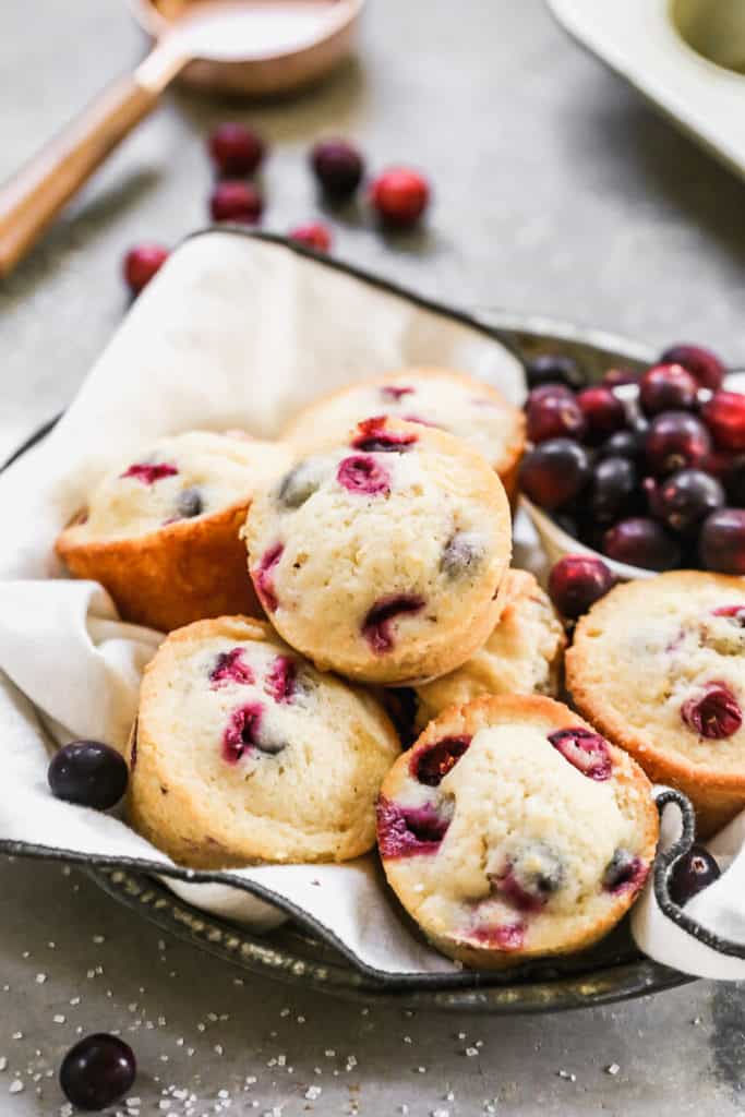Cranberry Orange Muffins stacked on a baking sheet 
