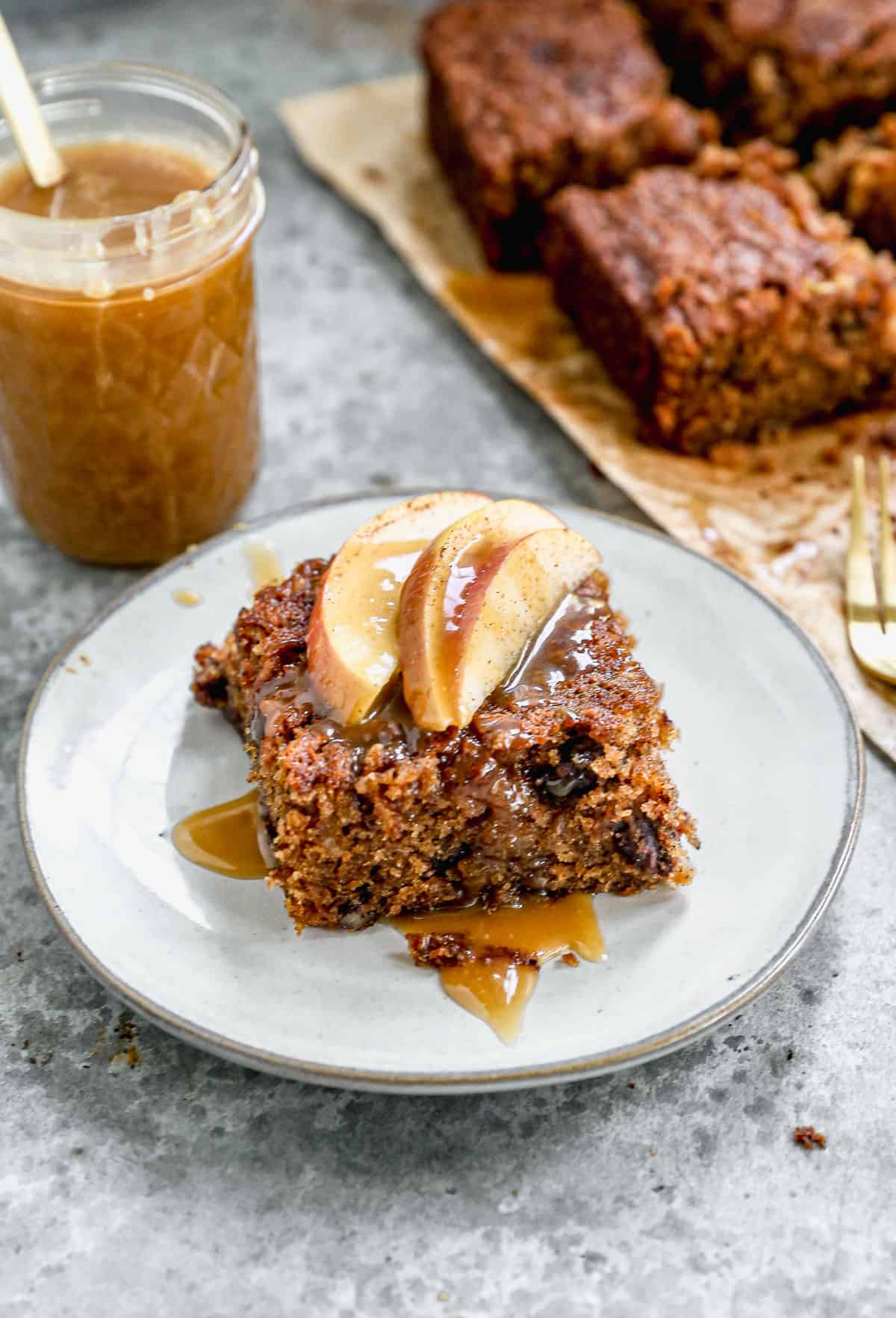 Rich Apple Cake served with sliced baked apples and homemade caramel sauce