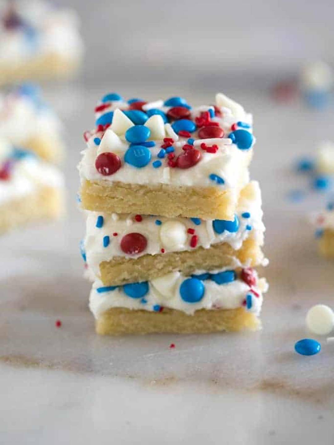 Patriotic Sugar Cookie Bars stacked on a marble slab.