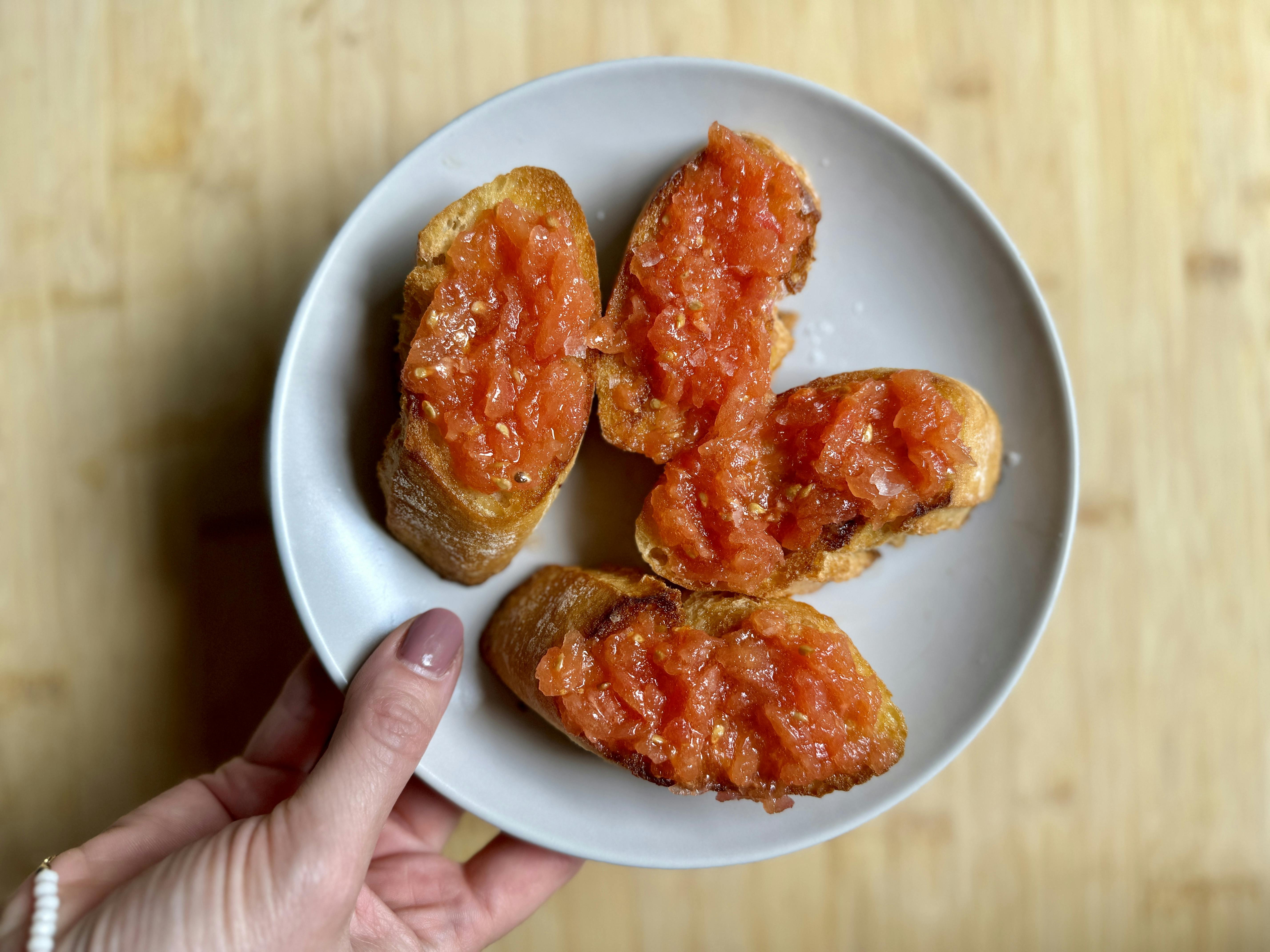 Slices of pan con tomate (toast with tomato spread), on a plate.