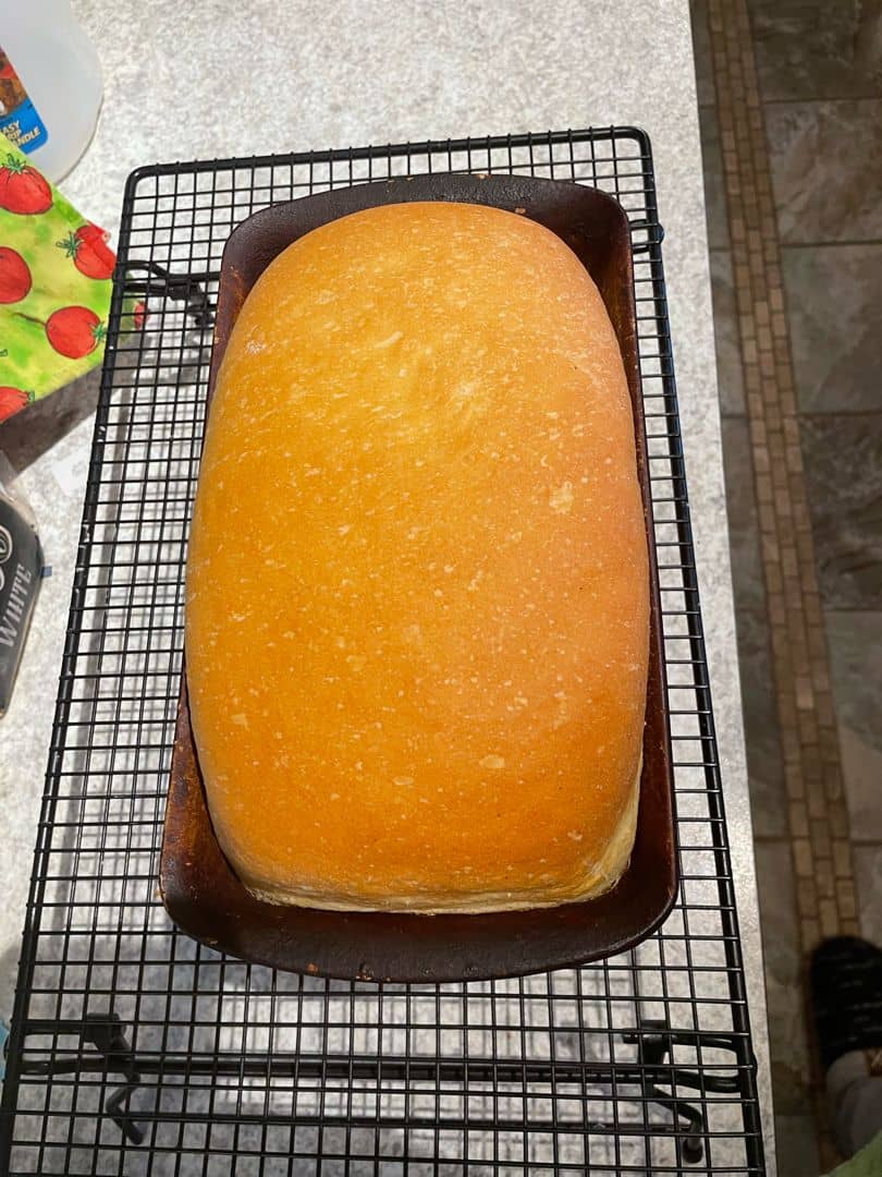 Homemade Bread image sent from a subscriber in a bread pan sitting on a cooling rack.