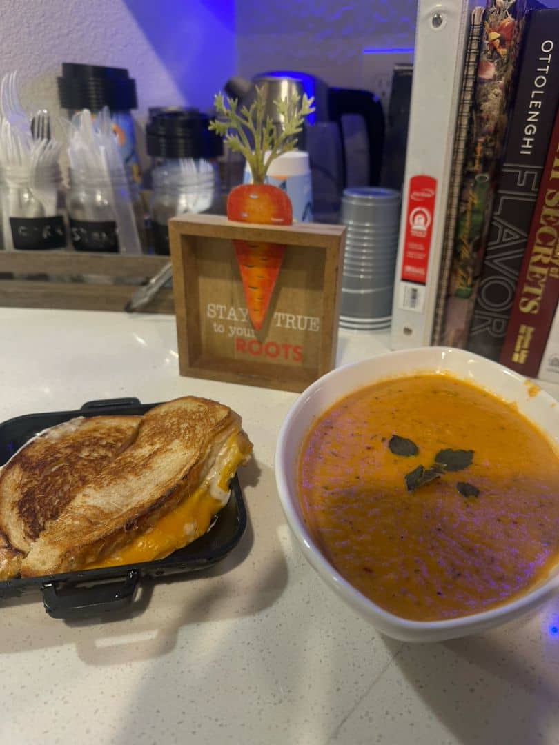A warm bowl of creamy tomato basil parmesan soup with a rich, velvety texture, garnished with fresh basil and shredded parmesan. Cozy, comforting, and perfect with a slice of crusty bread.