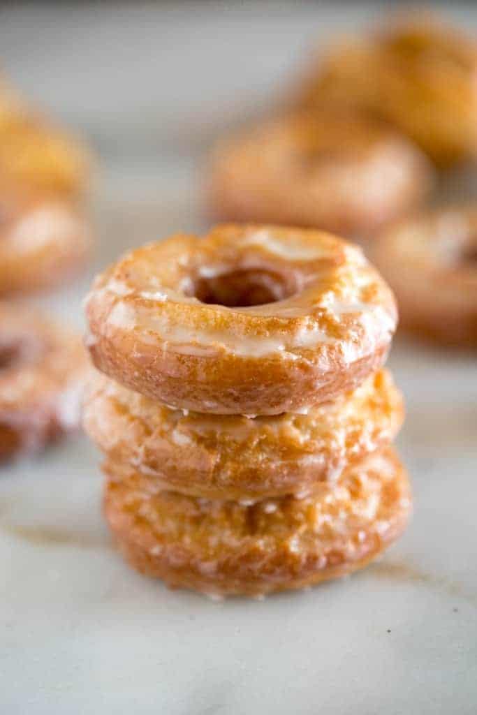 Old-Fashioned Sour Cream Donuts stacked on a marble slab and coated in a delicious glaze 