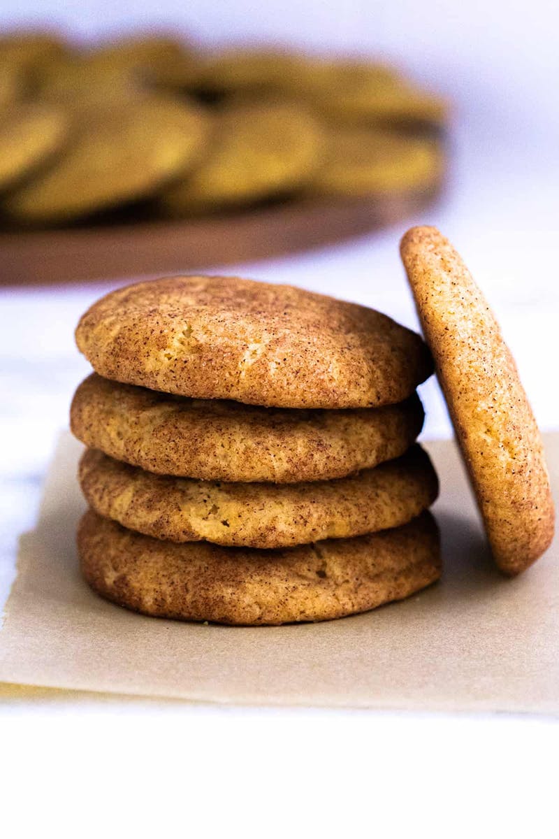 Pumpkin Snickerdoodles stacked on a piece of parchment paper