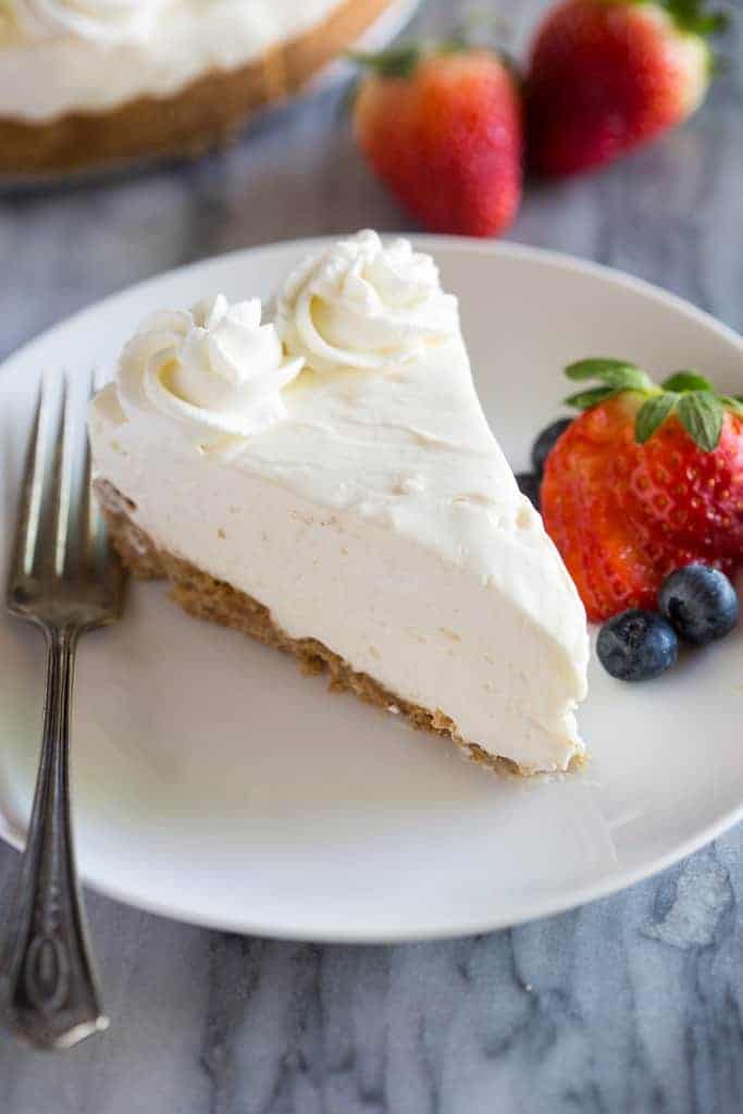 no bake cheesecake on a white plate with a fork and berries also on the plate