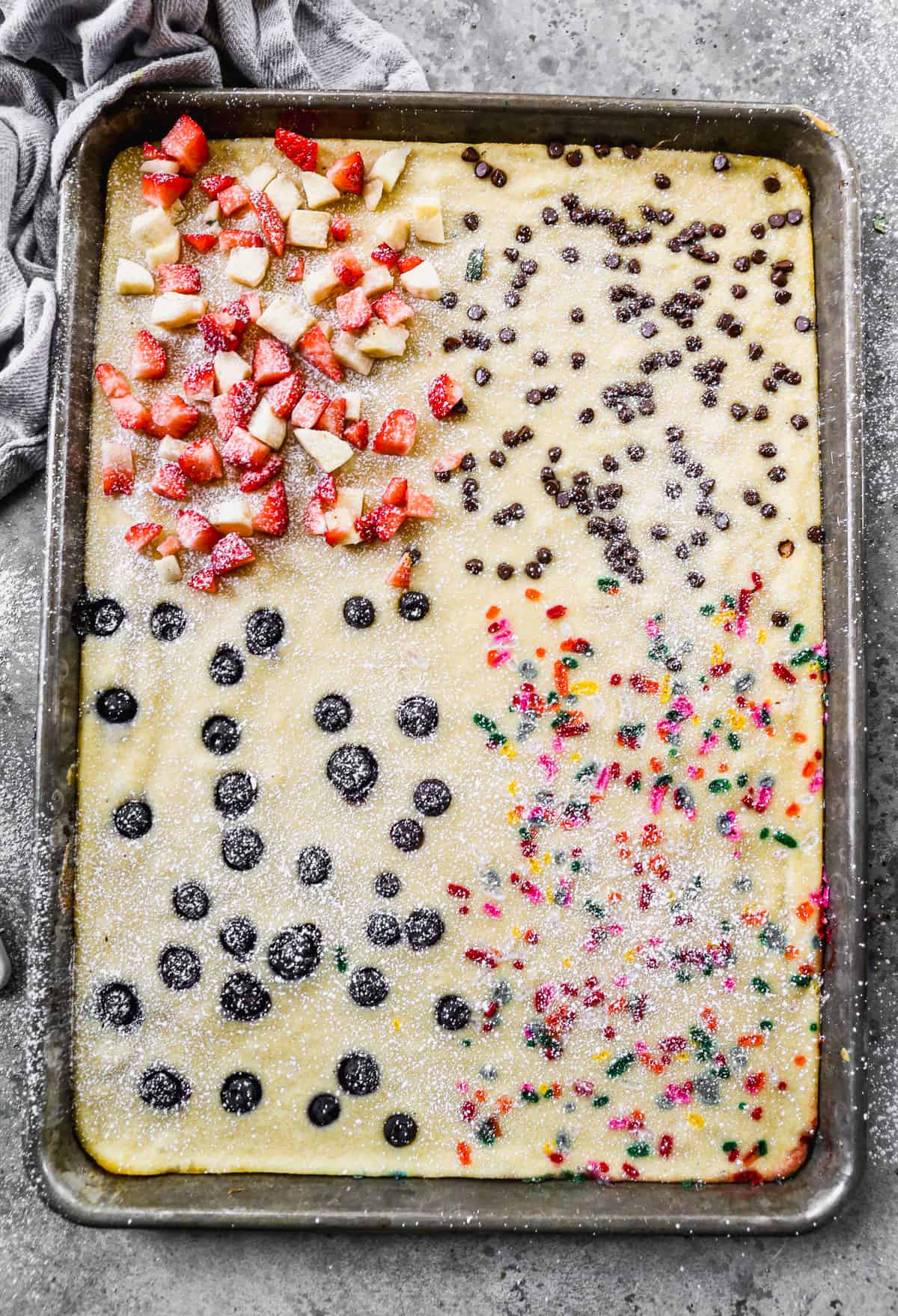 Sheet Pan Pancakes topped with a variety of fruits and chocolate. 