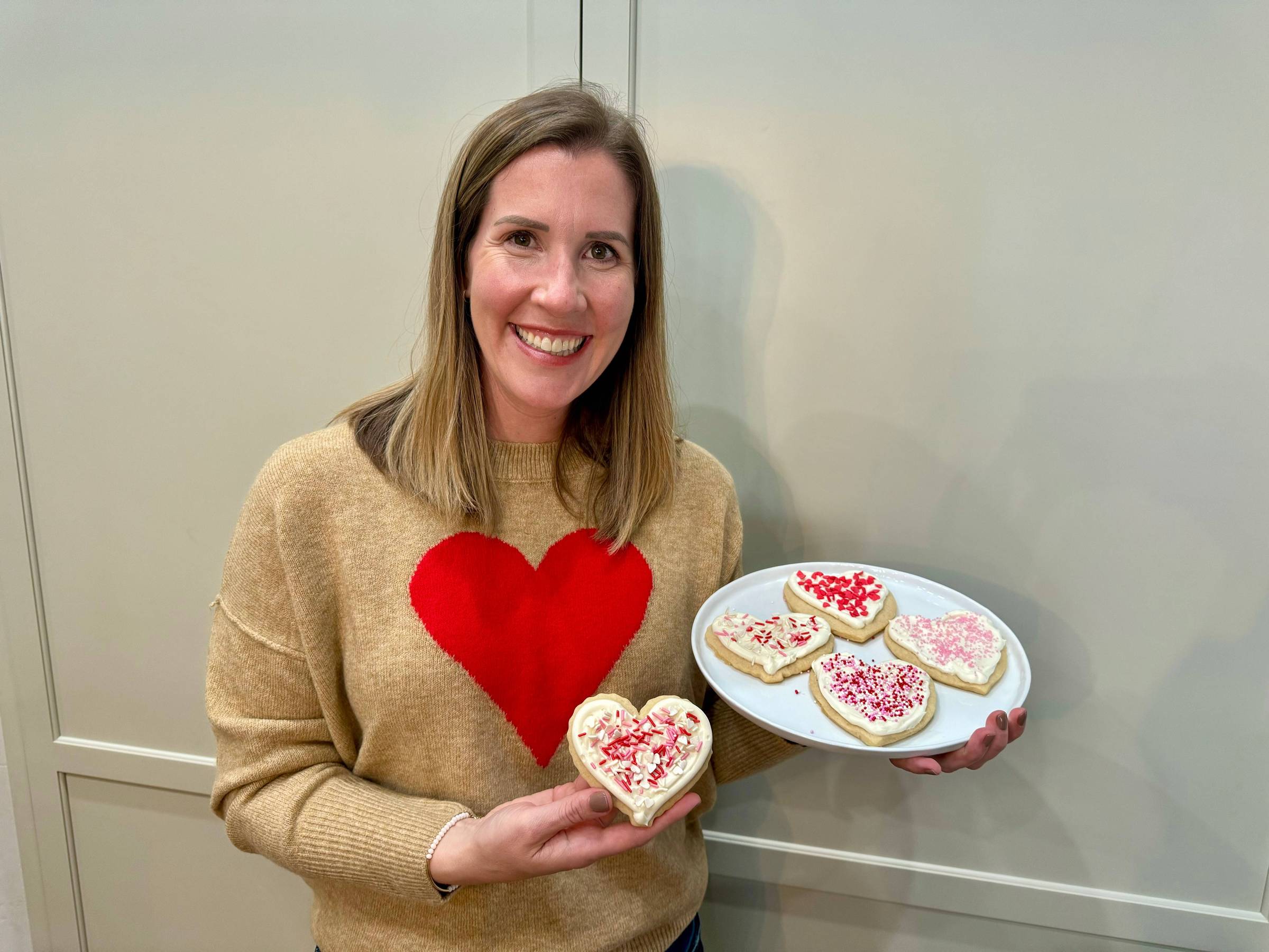 Lauren holding a plate of heart cookies.