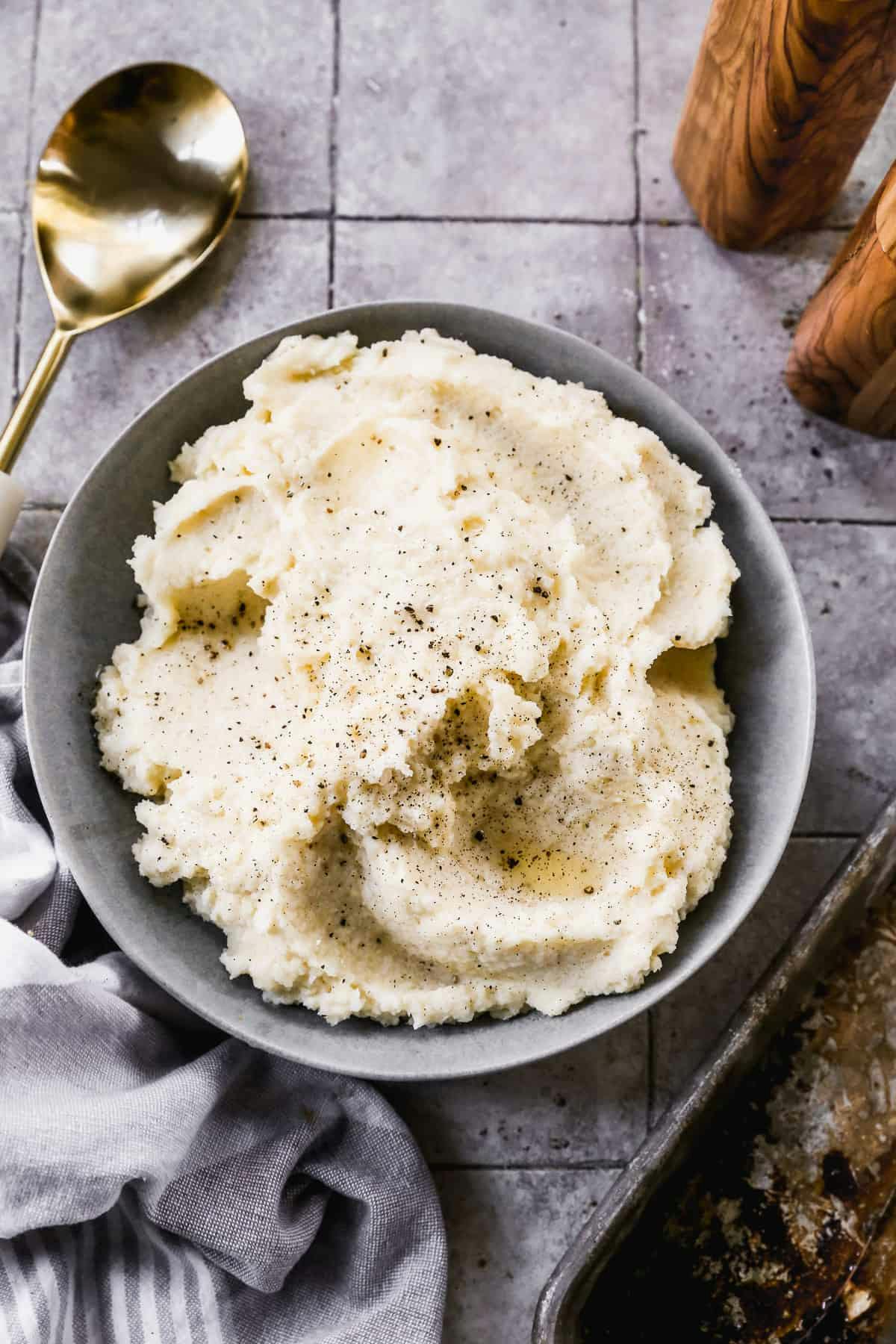 Mashed Potatoes in a grey bowl garnished with pepper