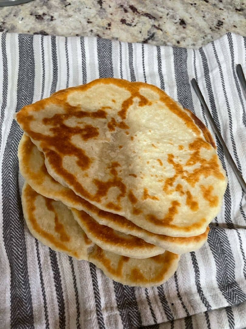 Subscriber image of pita bread on a striped grey towel.