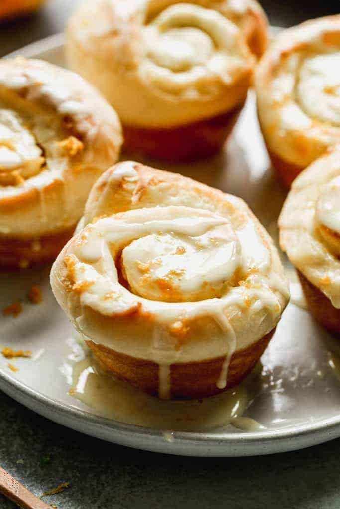 Orange Rolls fresh out of the oven on a baking tray and drizzled with glaze