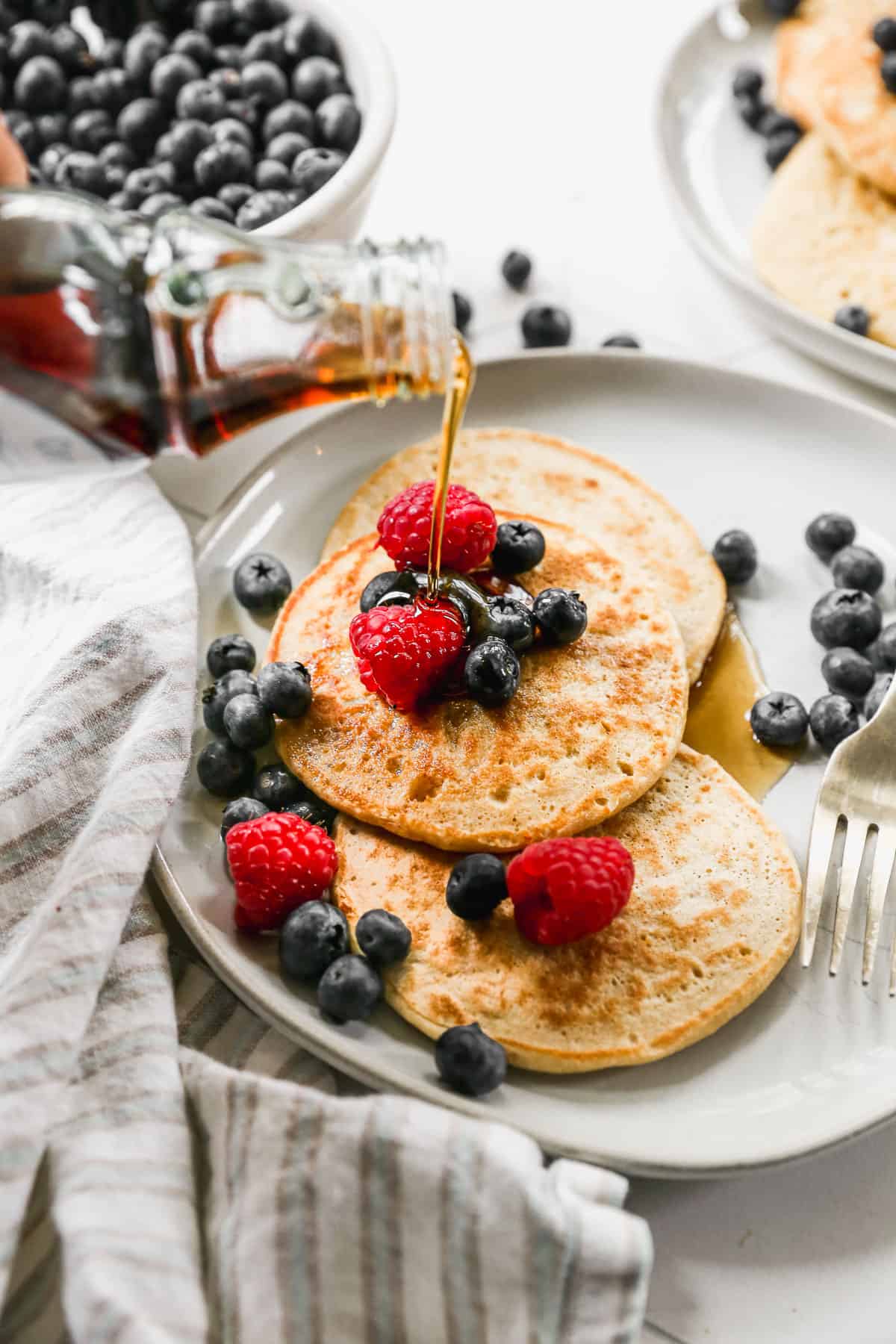 Cottage Cheese Pancakes topped with fresh berries and served with delicious homemade syrup!