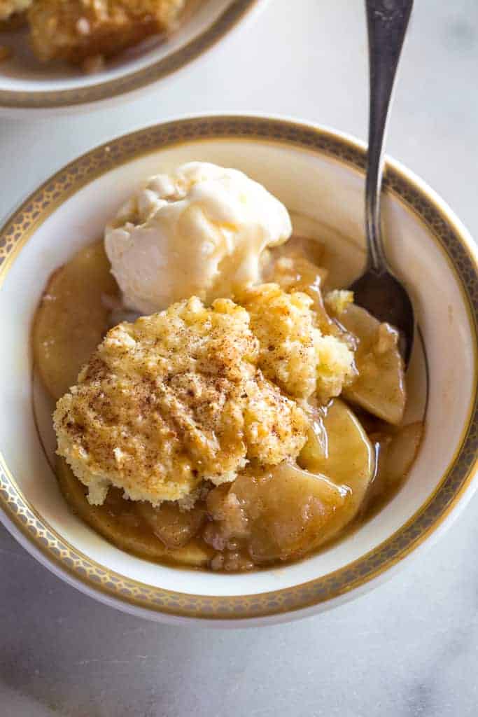 apple cobbler in a gold and white bowl