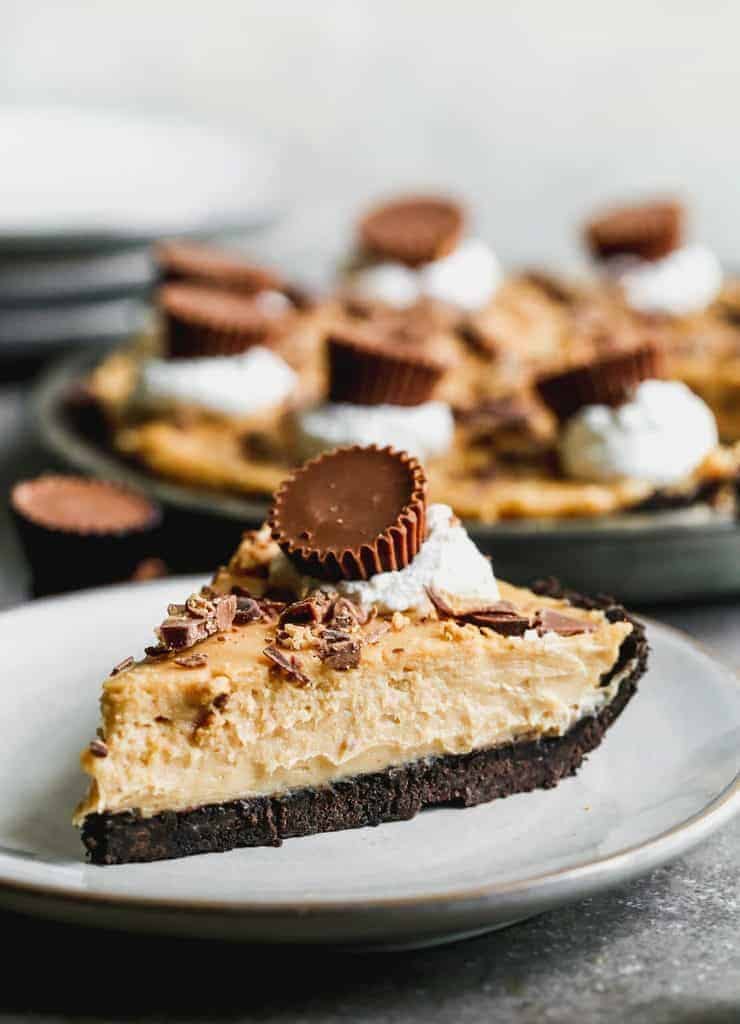 peanut butter pie with a chocolate crust, whipped cream and a peanut butter cup on top