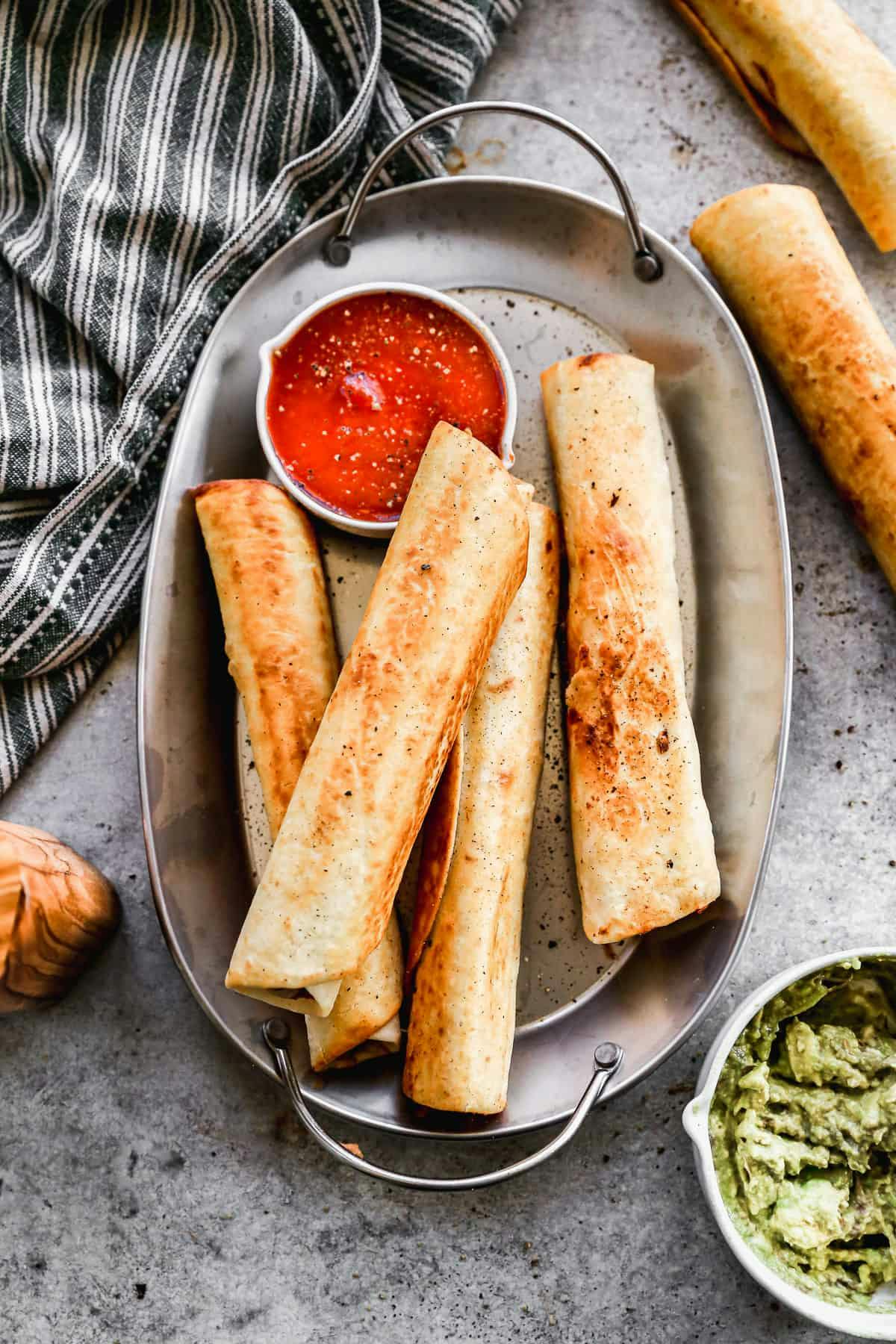 Crispy Bean and Cheese Burritos served with a tomato based dipping sauce  and guacamole 