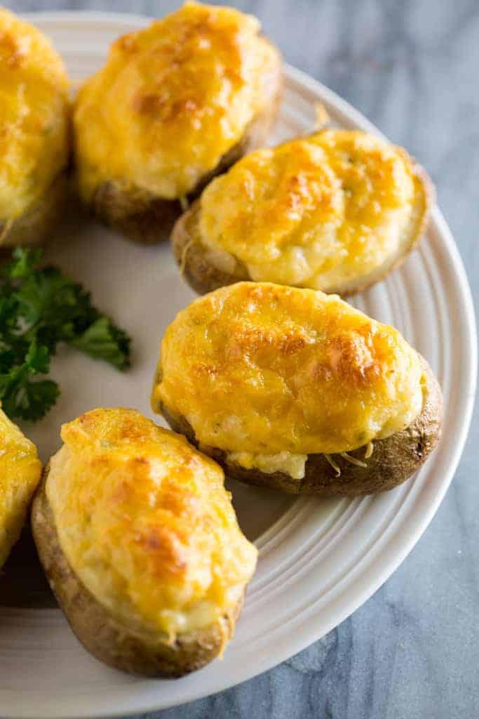 Twice Baked Potatoes served on a white plate and garnished with fresh herbs