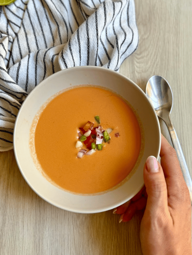 Gazpacho in a bowl with garnish.