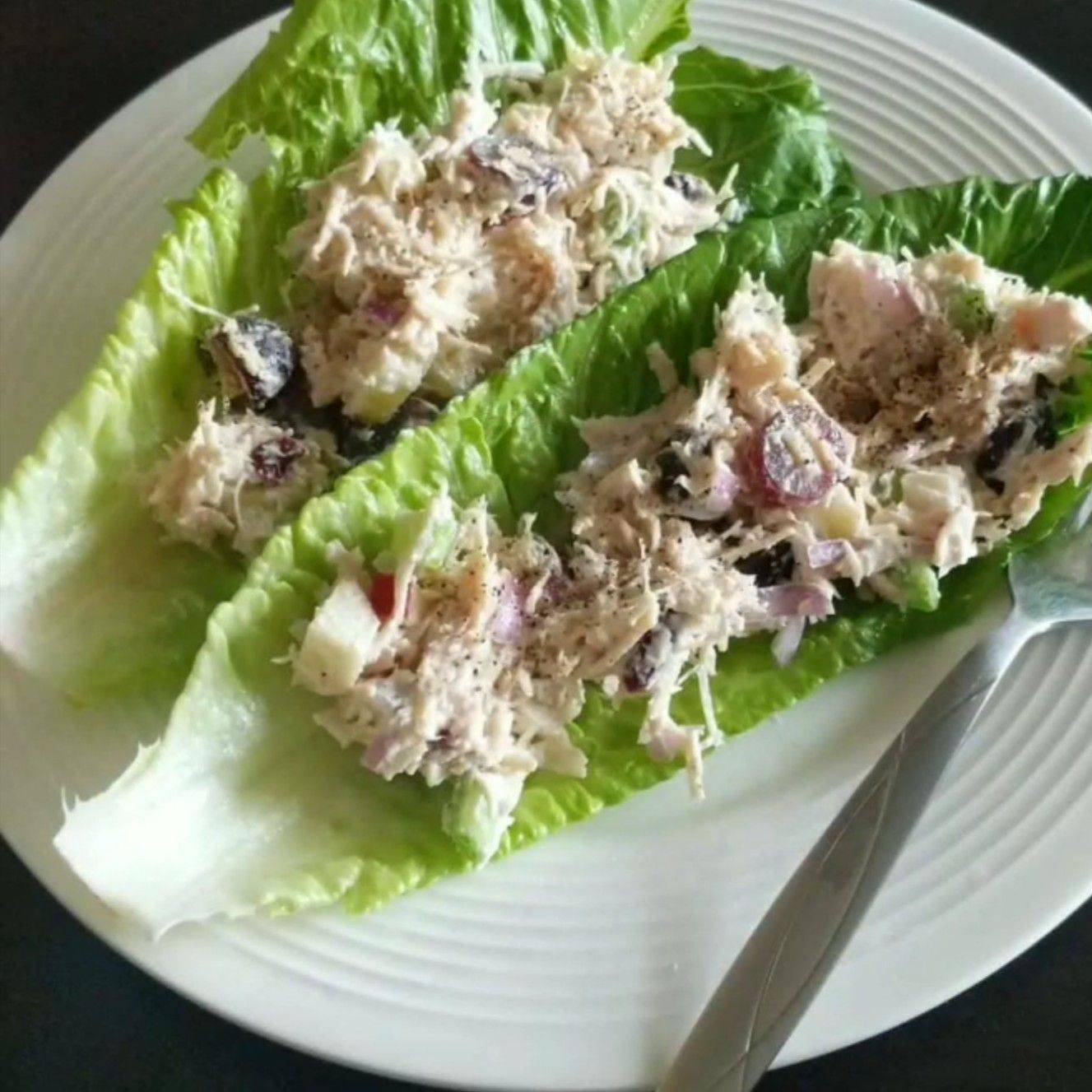 A crisp lettuce leaf cradling creamy Greek yogurt chicken salad, loaded with tender chunks of chicken, red grapes, celery, and toasted almonds—simple, fresh, and perfect for lunch on the go.