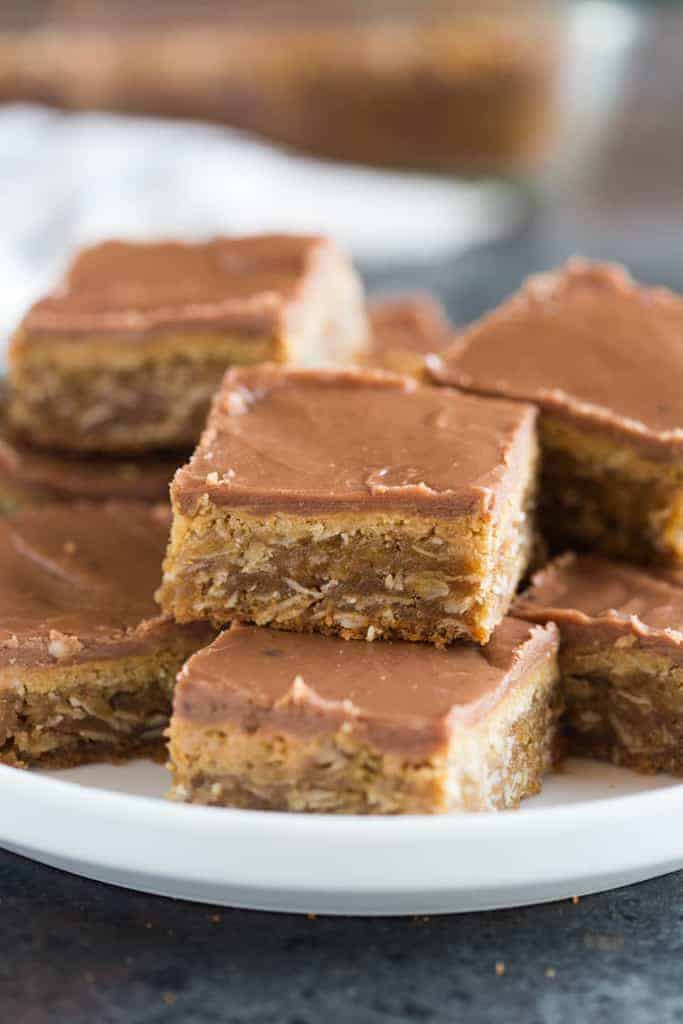 Peanut Butter Bars with chocolate peanut butter frosting stacked on a white plate