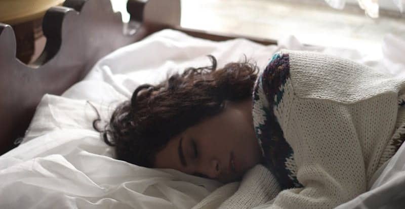 woman sleeping on bed beside book