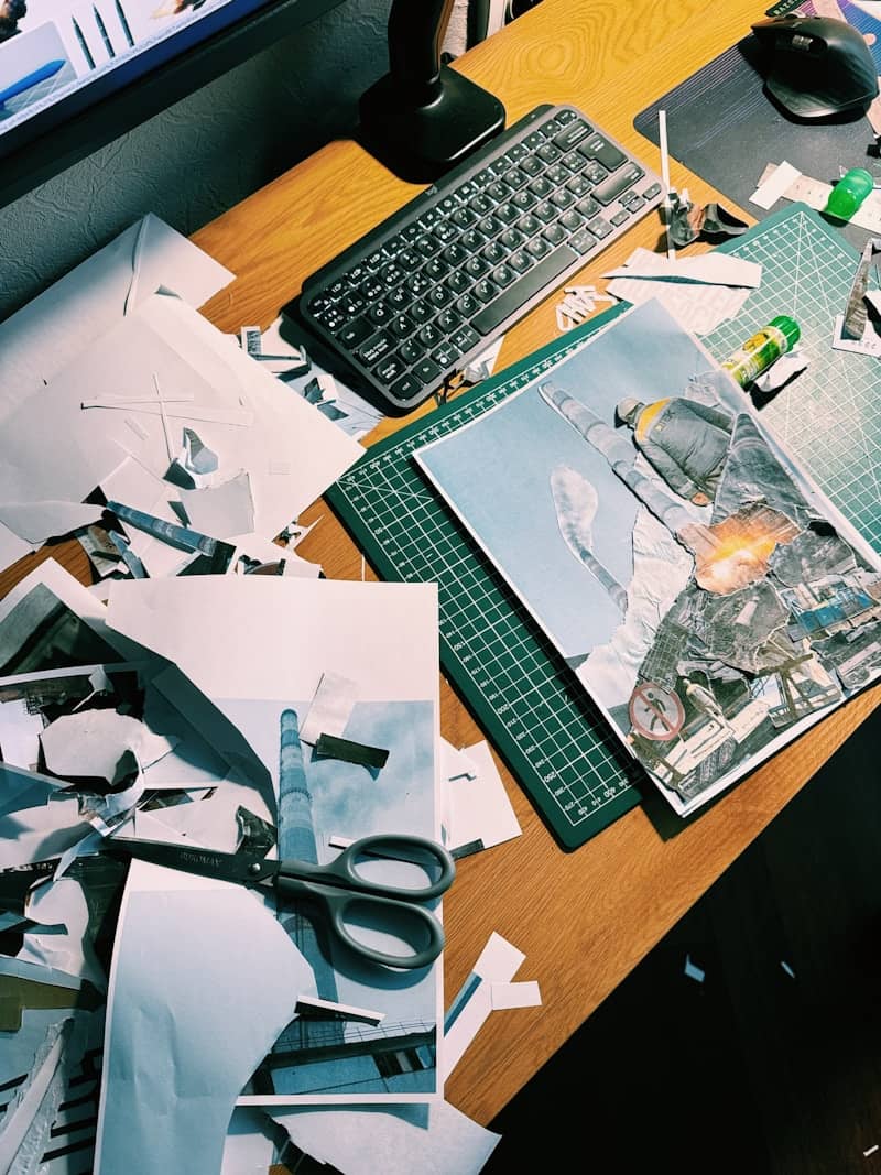Messy desk with scattered papers, scissors, and a keyboard.
