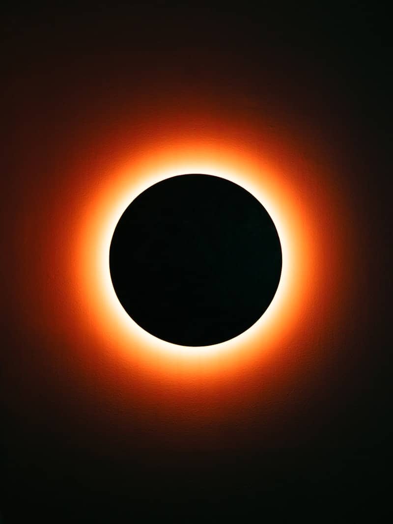 A solar eclipse with a bright orange corona