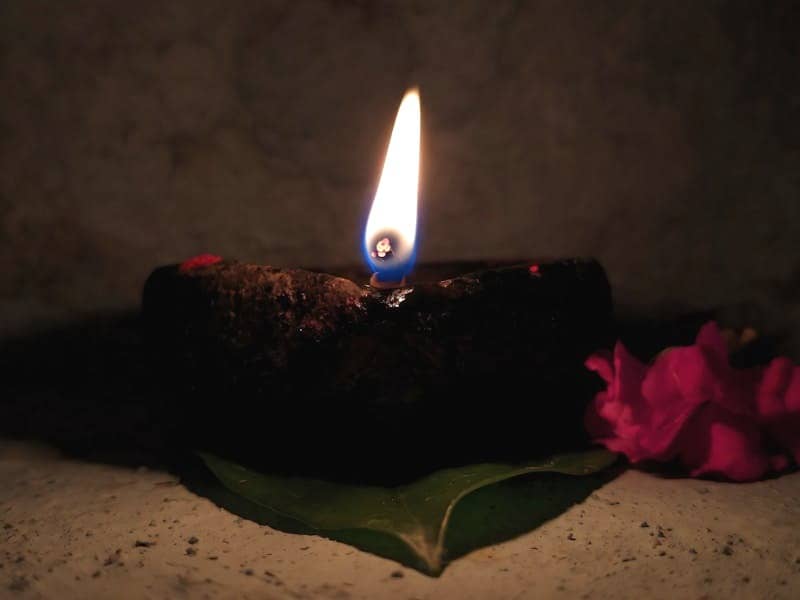 A lit candle sitting on top of a green plate