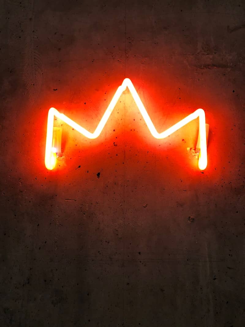 a neon crown that is on the side of a wall