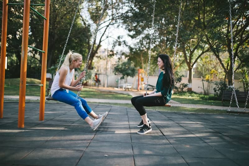 women sitting on swings