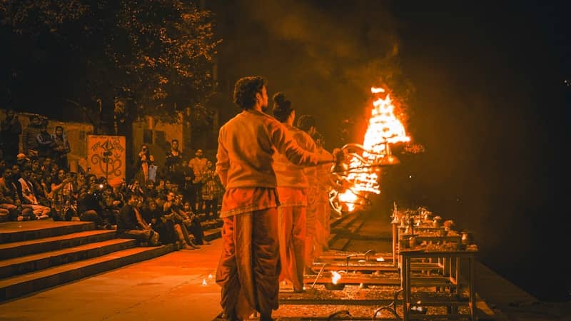 a couple of men standing in front of a fire