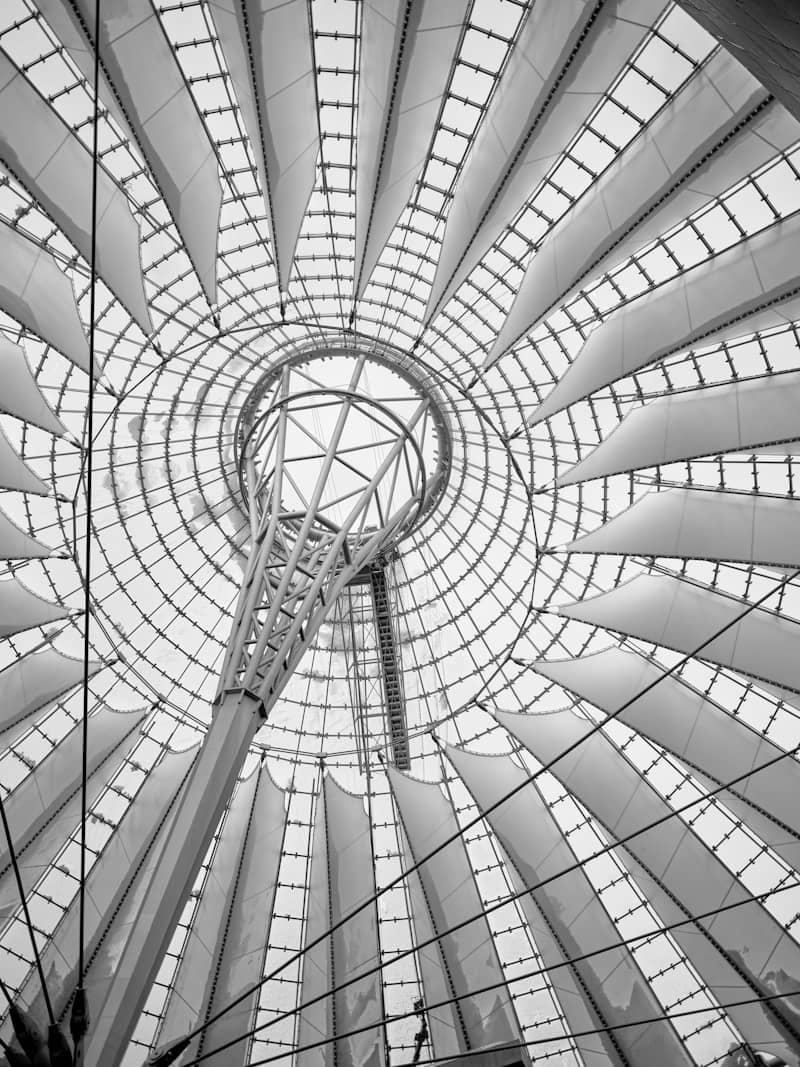 Modern building's geometric ceiling structure viewed from below.