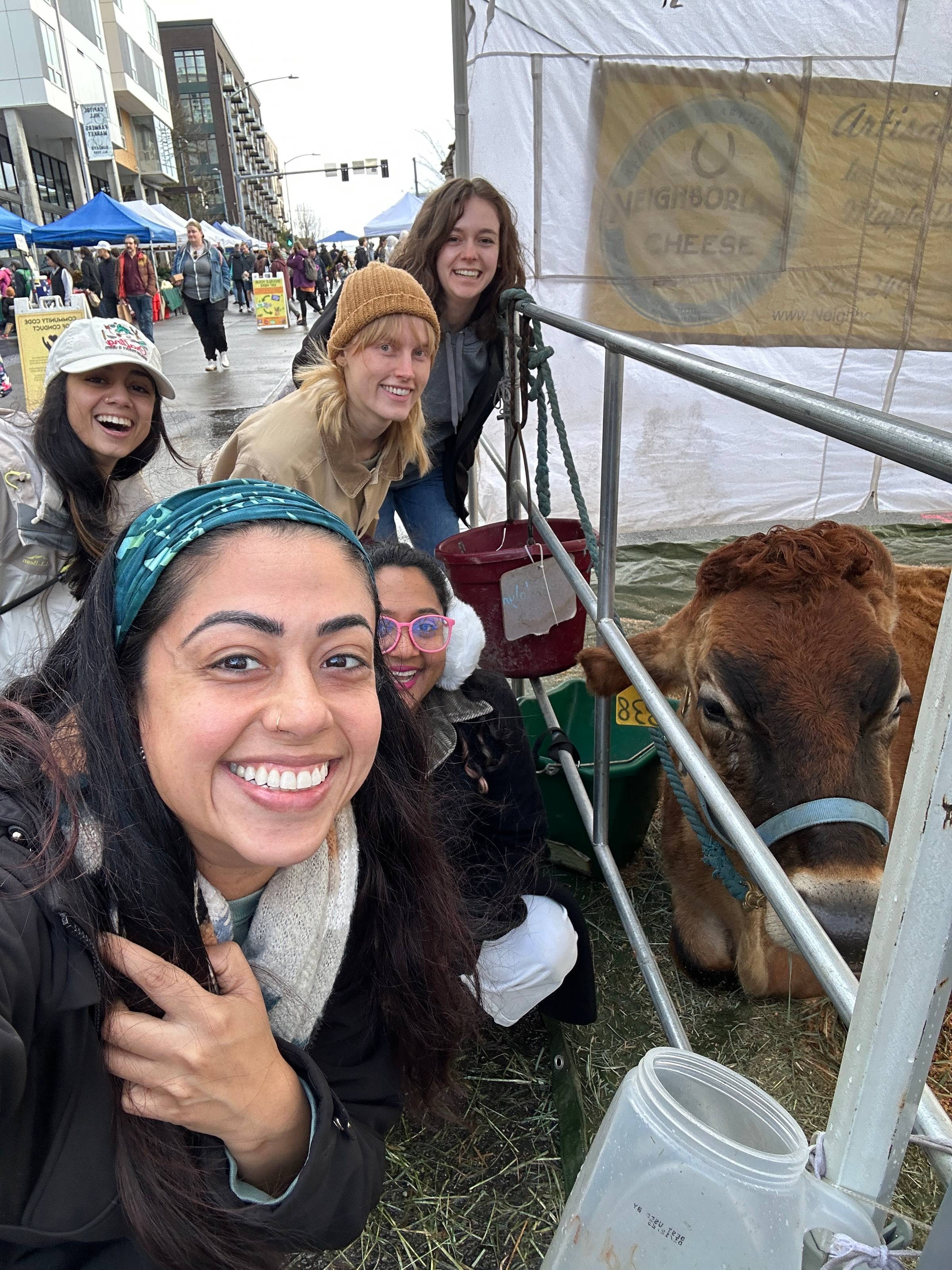 Soapbox Seattle volunteers at the farmers market with a cow