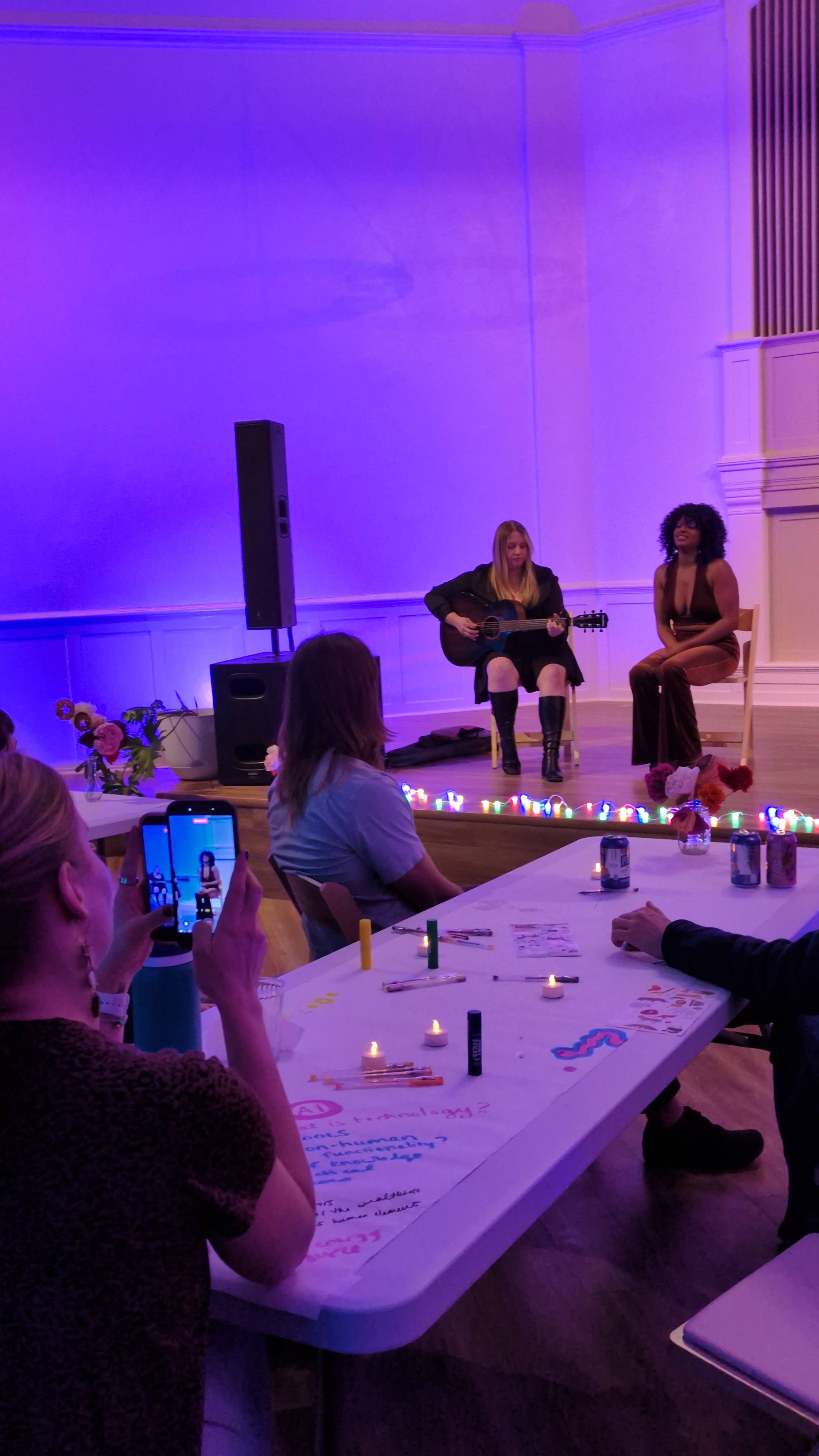Kingsley and Hannah DiMo playing Dream Sessions to a group of Portlanders in a vibrantly lit hall