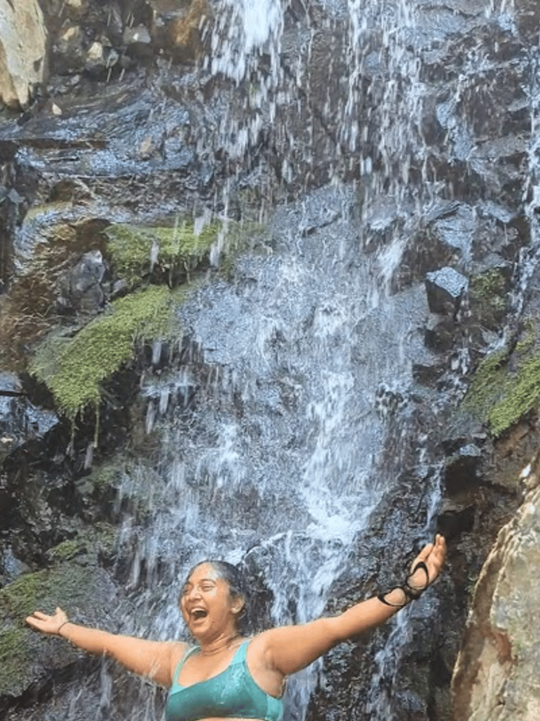 Nivi standing under a waterfall frea