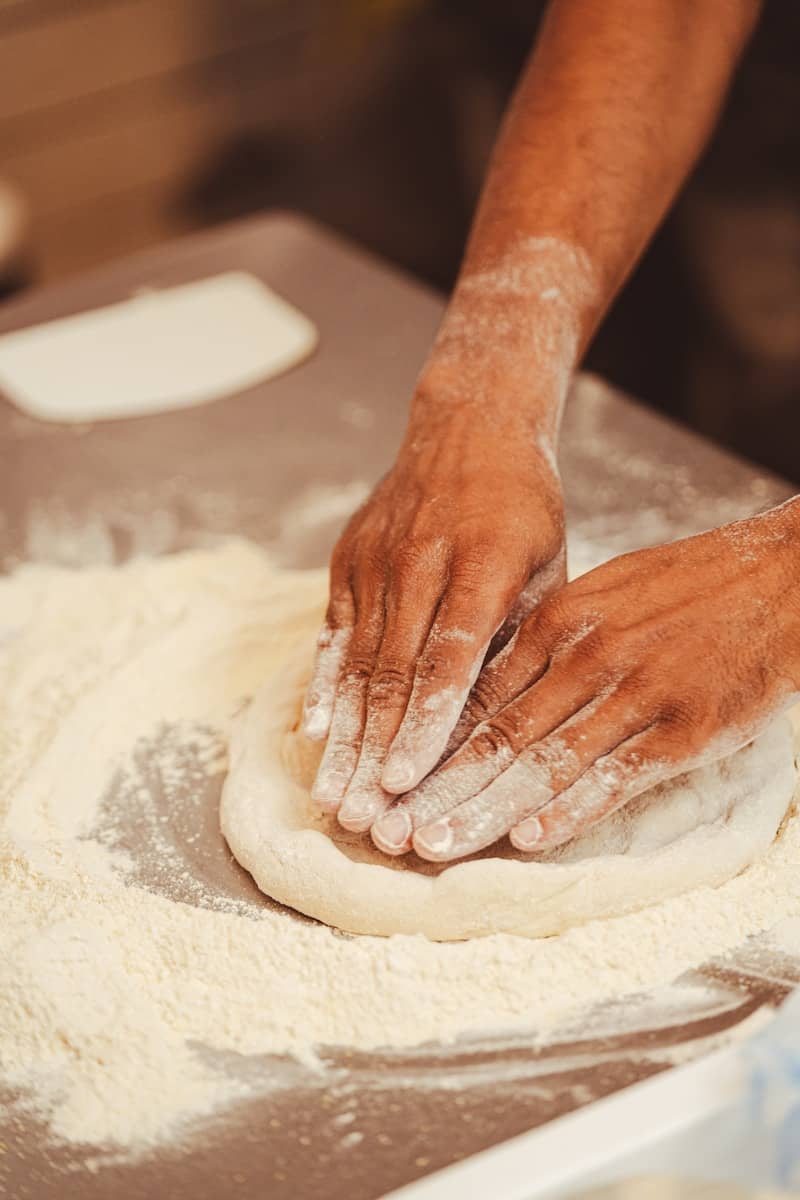 a person kneading dough on top of a table