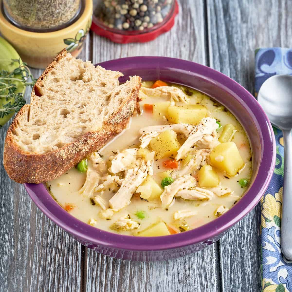 A bowl of chicken pot pie soup and a slice of bread