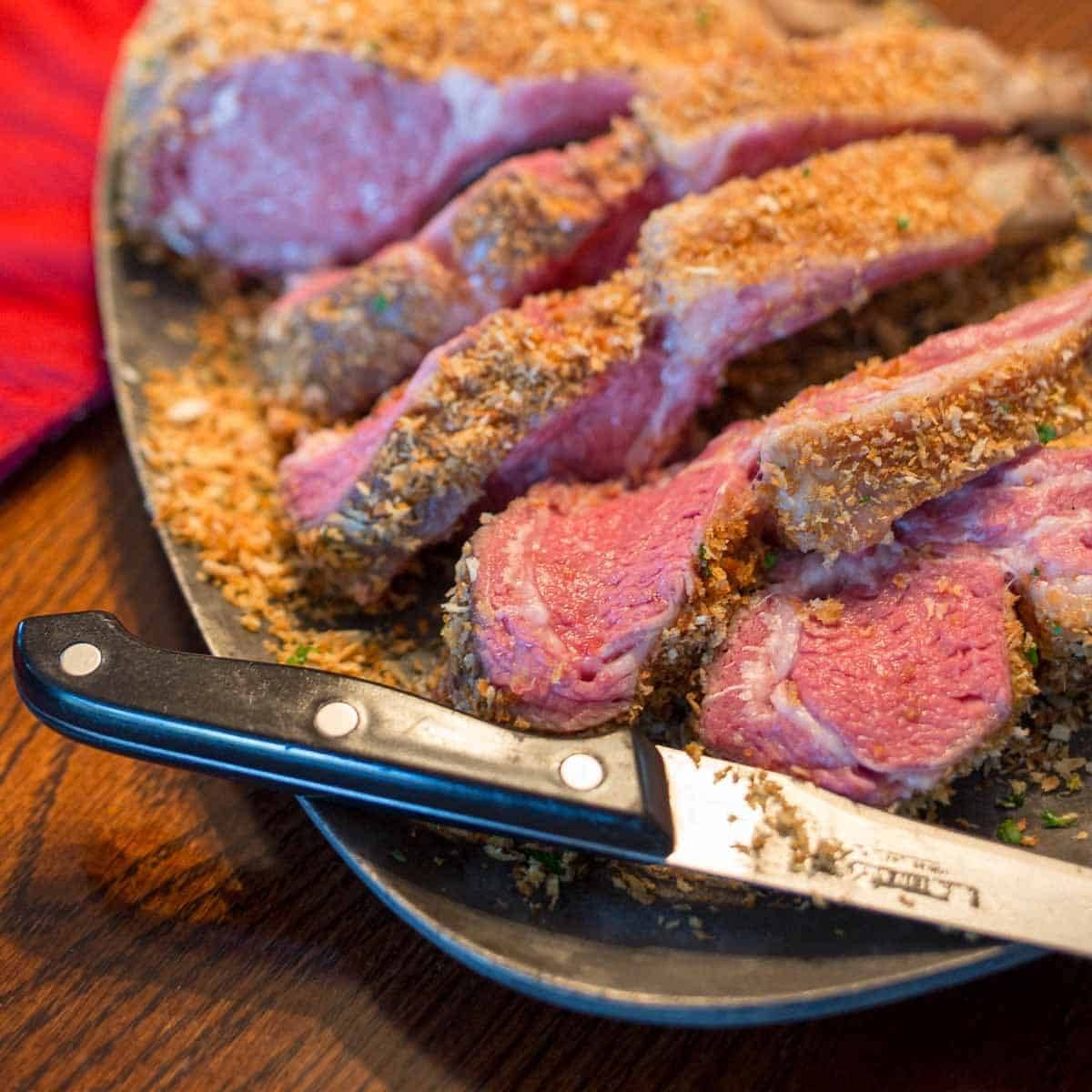 A platter of rack of lamb chops with a bread crumb crust