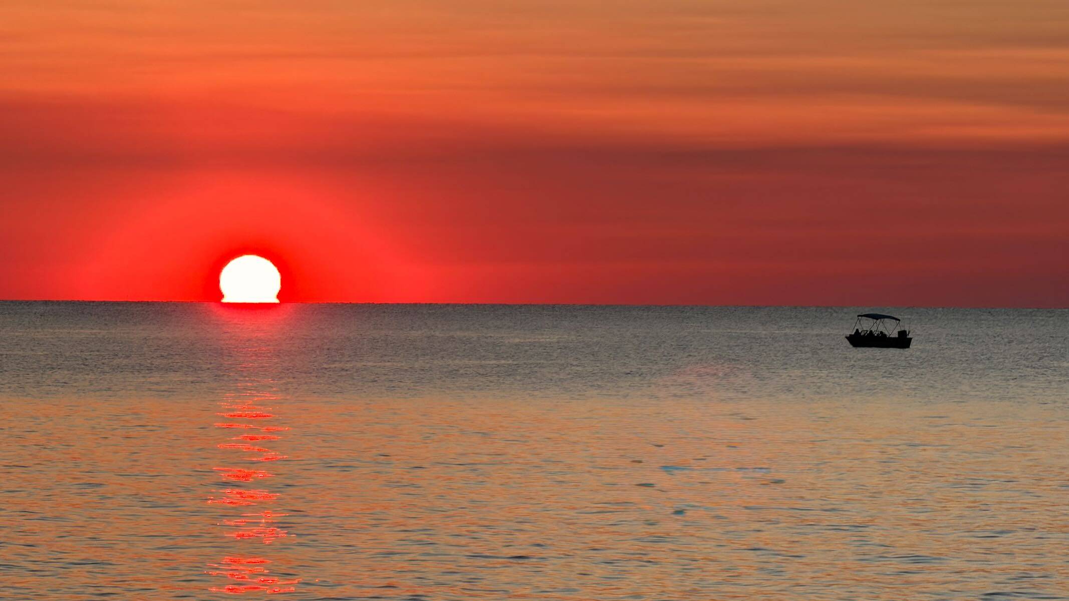 Sun setting over Lake Erie with a boat in silhouette