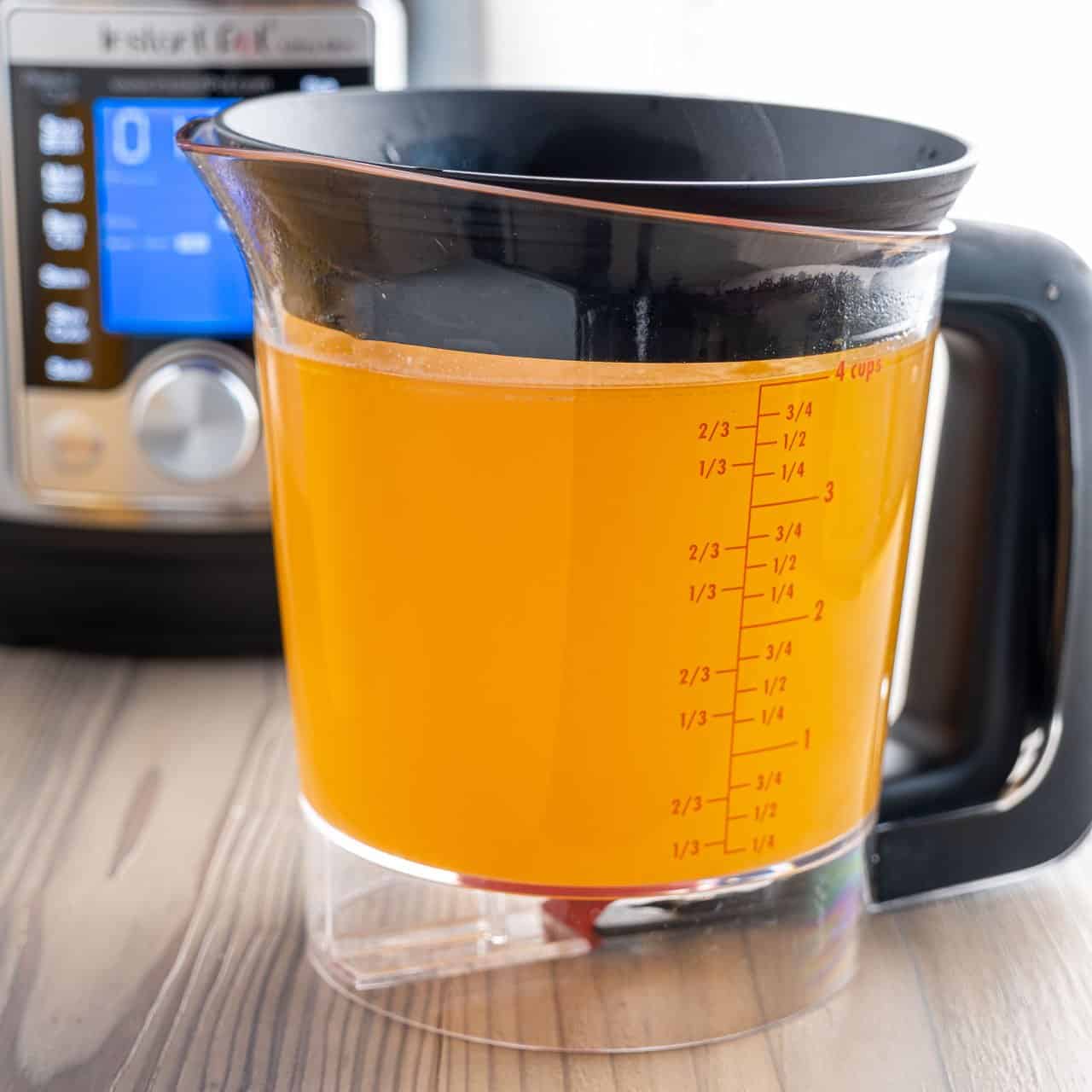 A fat separator full of rotisserie chicken broth