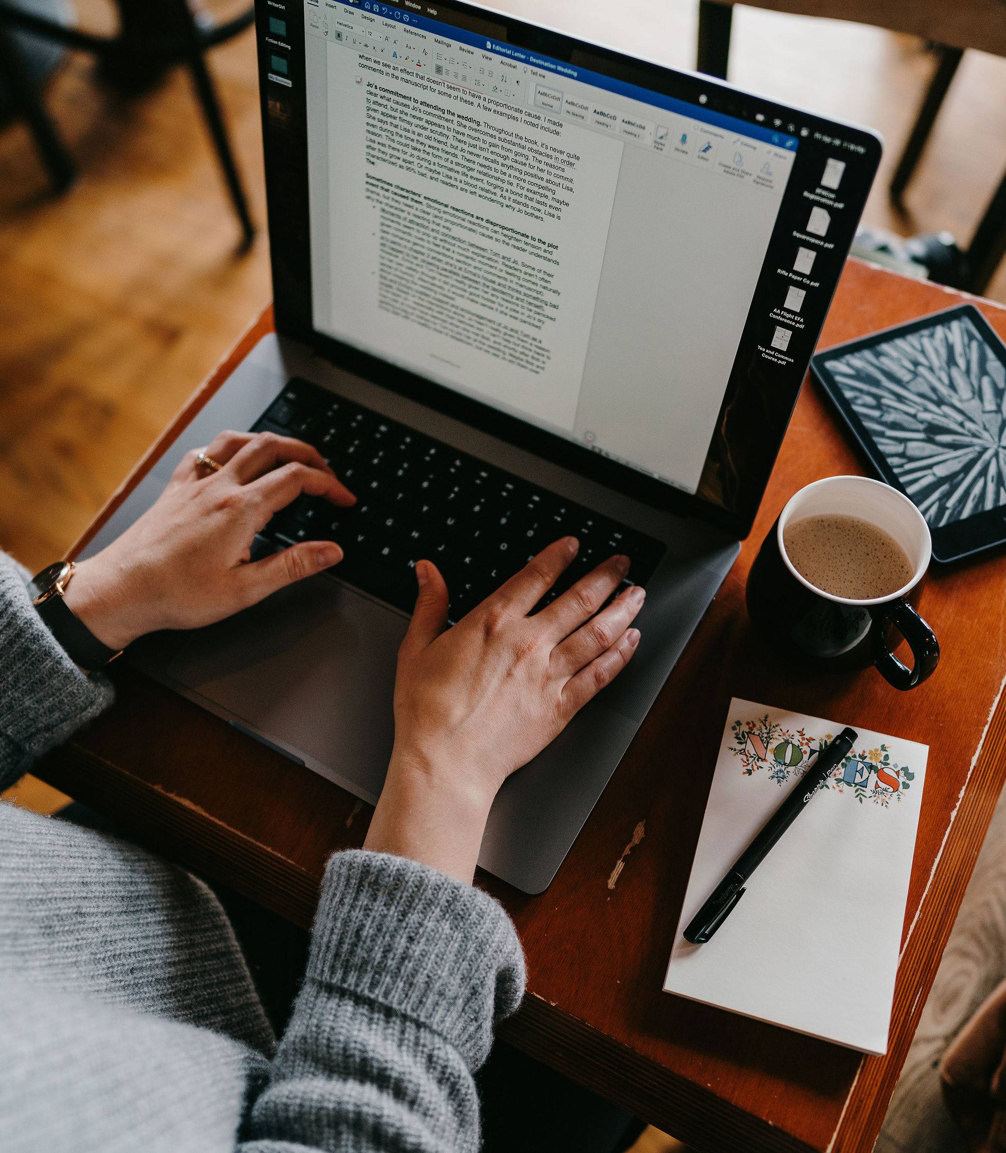 A woman typing on her laptop to revise a fiction manuscript