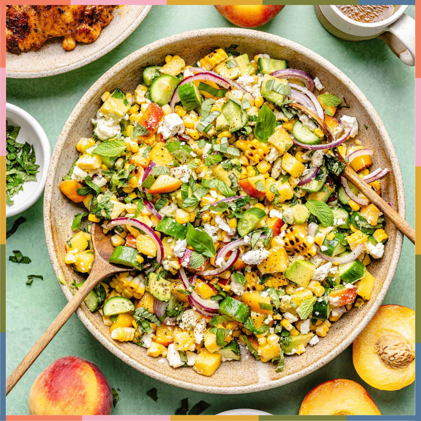 peach feta salad with hot honey dressing in mixing bowl with 2 spoons