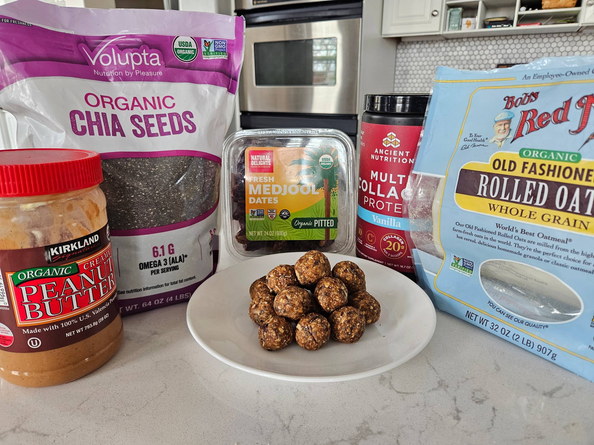 Protein balls on a plate in front of the 5 ingredients used to make them.