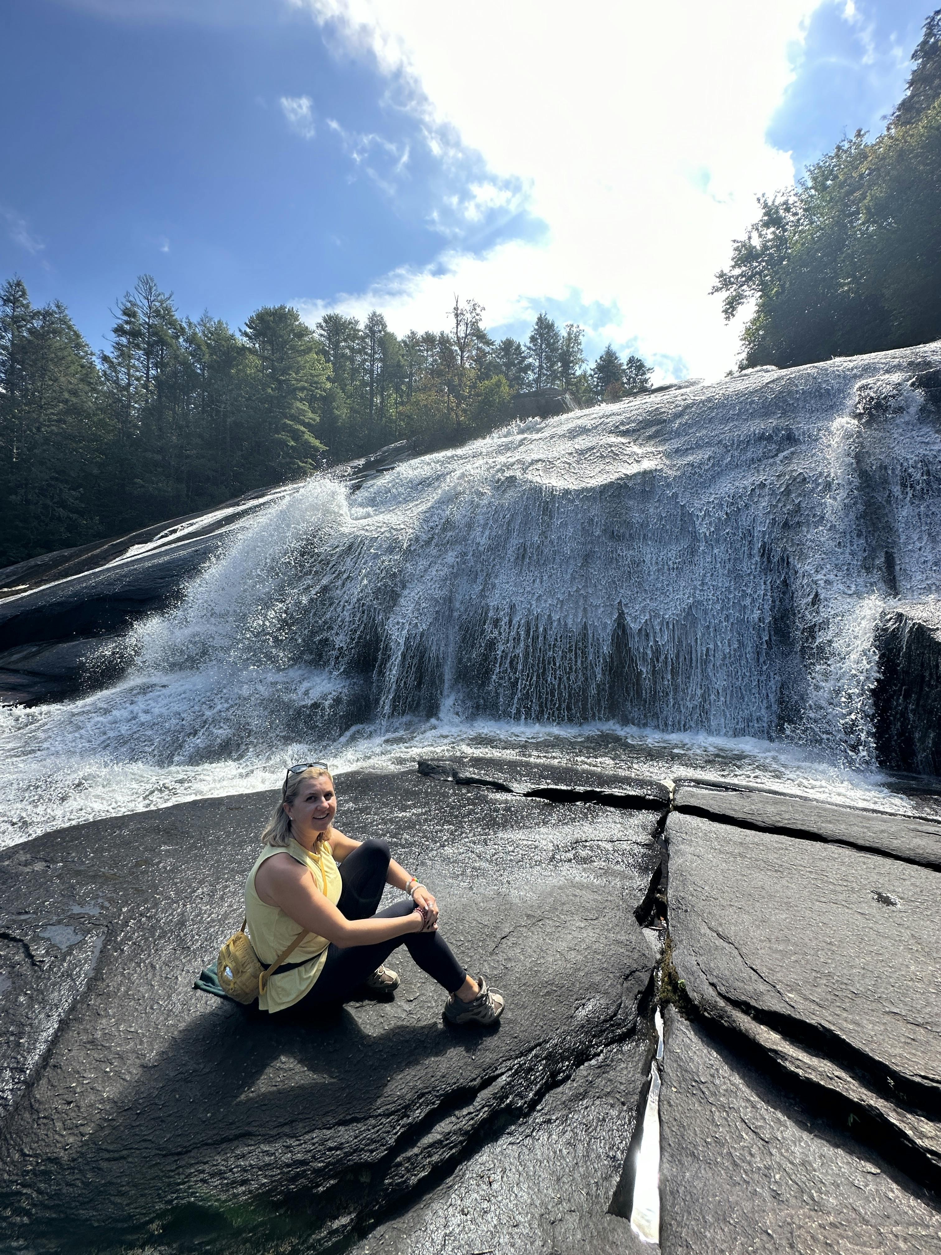 A girl sitting by a waterfall