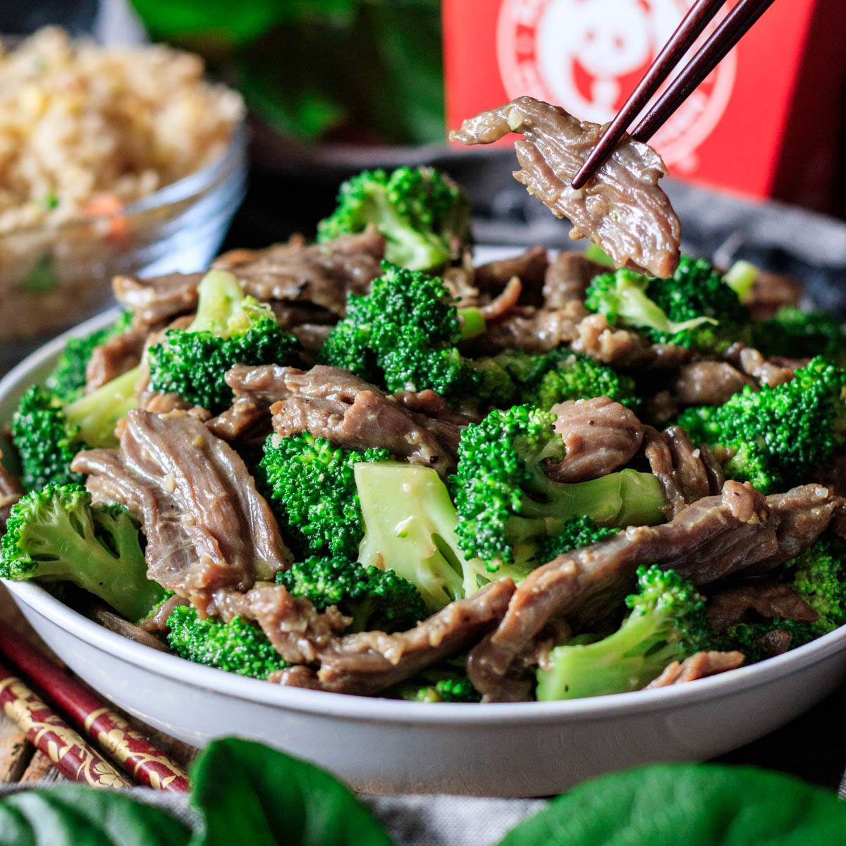 holding a piece of Panda Express broccoli beef with chopsticks.