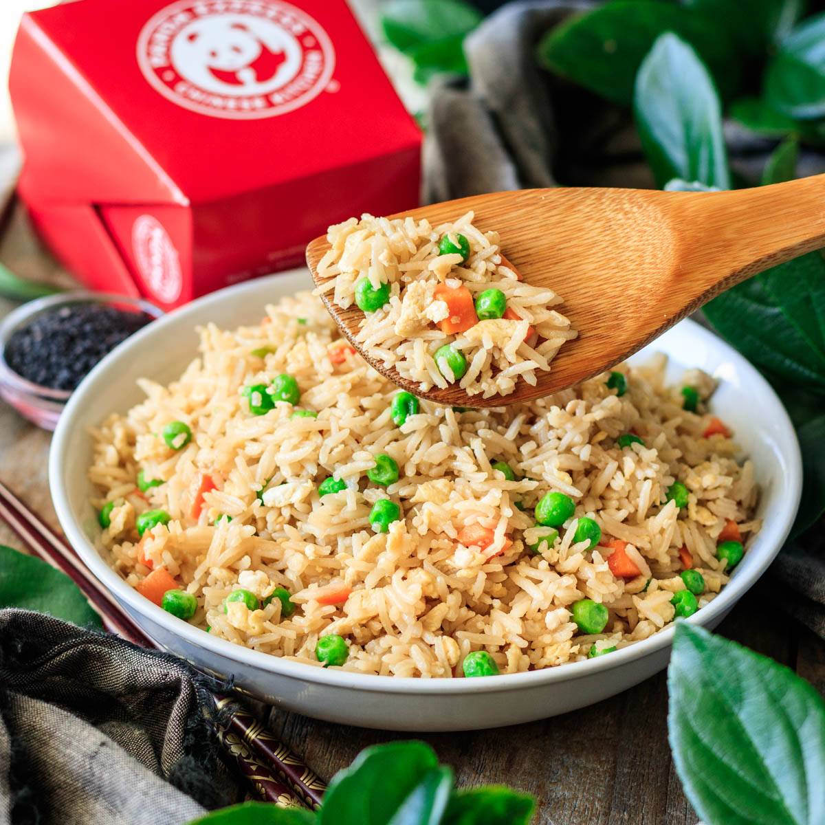white bowl of Panda Express fried rice with a wooden spoon.