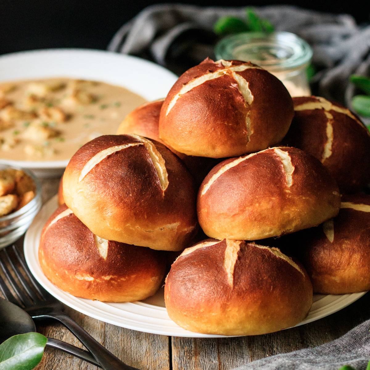 pile of pretzel buns on a white plate.