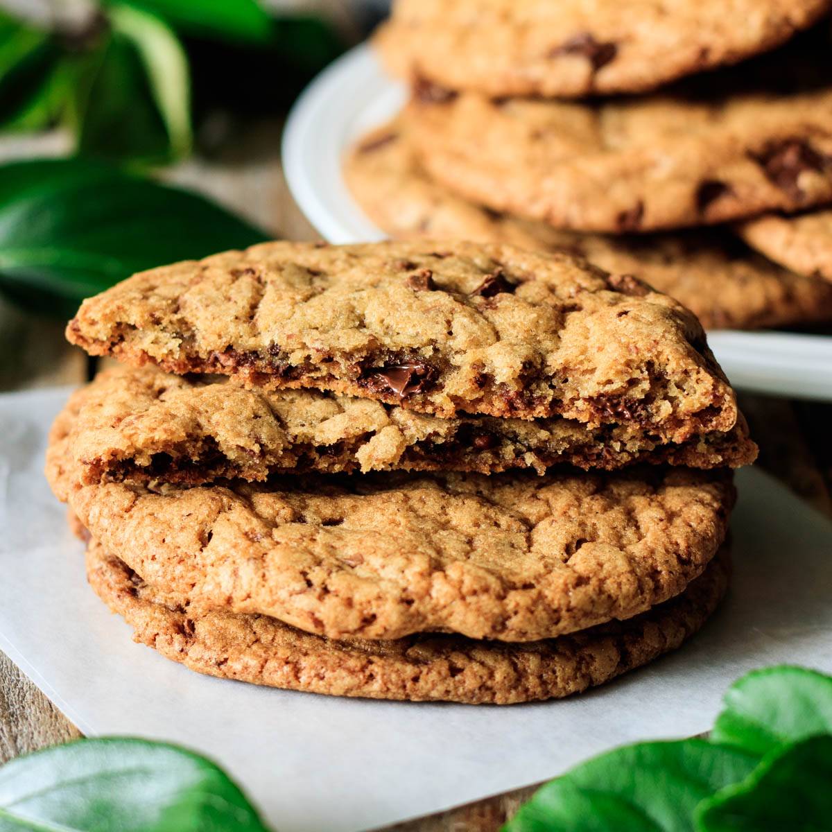 stack of chocolate chipper cookies on wax paper.