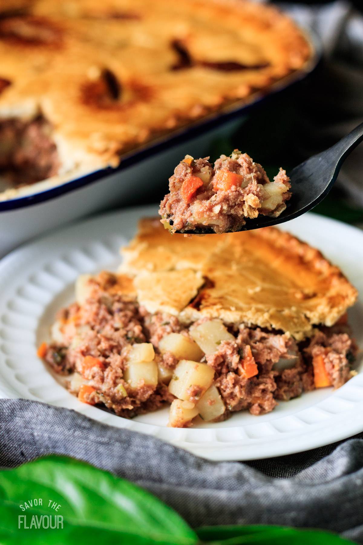 forkful of corned beef pie with a slice of pie.