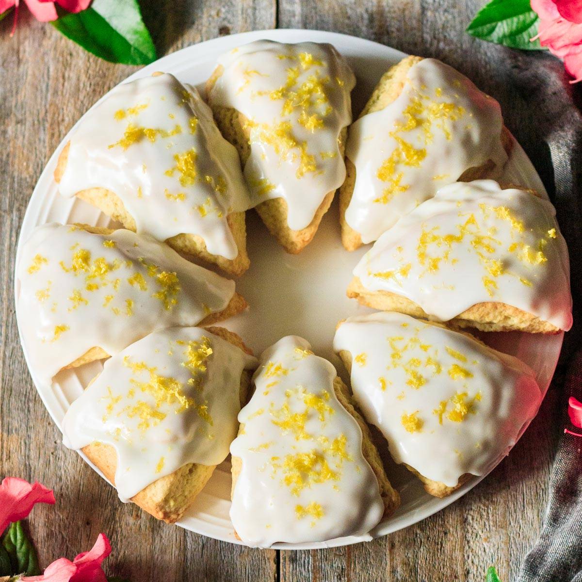 white plate of glazed lemon scones.